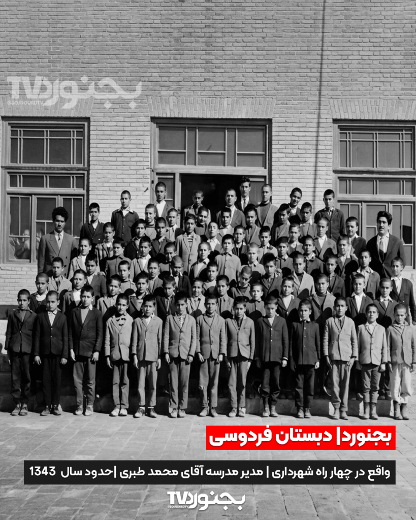 تصویر سیاه و سفید گروهی از دانش‌آموزان و معلمان دبستان فردوسی بجنورد در حیاط مدرسه آجری در سال ۱۳۴۳